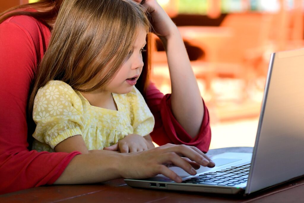 Szülő és gyermeke együtt kezelik a laptopot